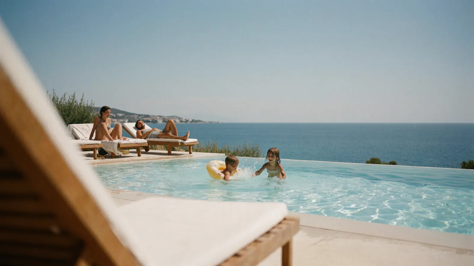 Children playing at the edge of a villa pool with parents nearby